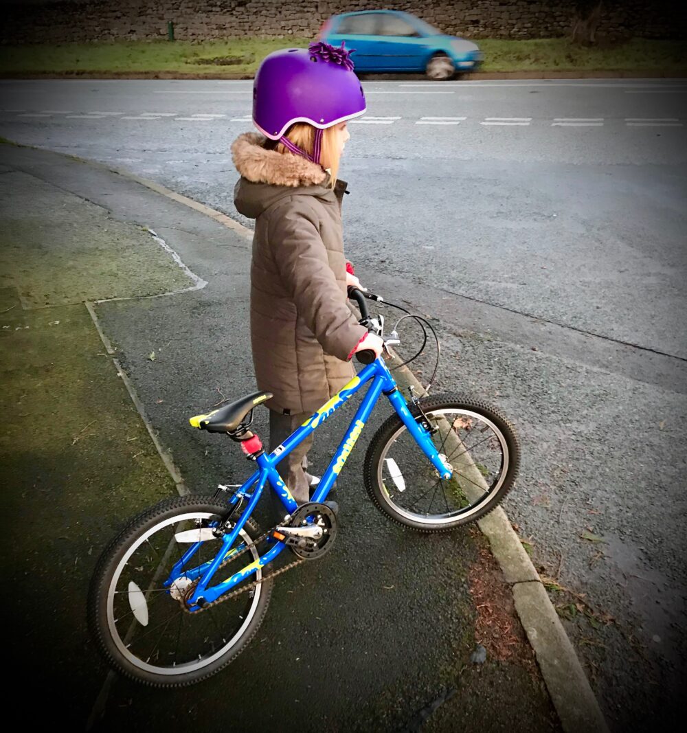 campaign for cycling infrastructure: Girl on the pavement with her bike