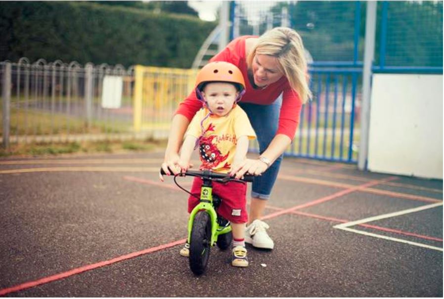Frog Tadpole Mini in use – one of the best balance bikes for a 1 year old toddler How to choose the right size kids' bike: A mum helping her toddler ride a Frog Tadpole