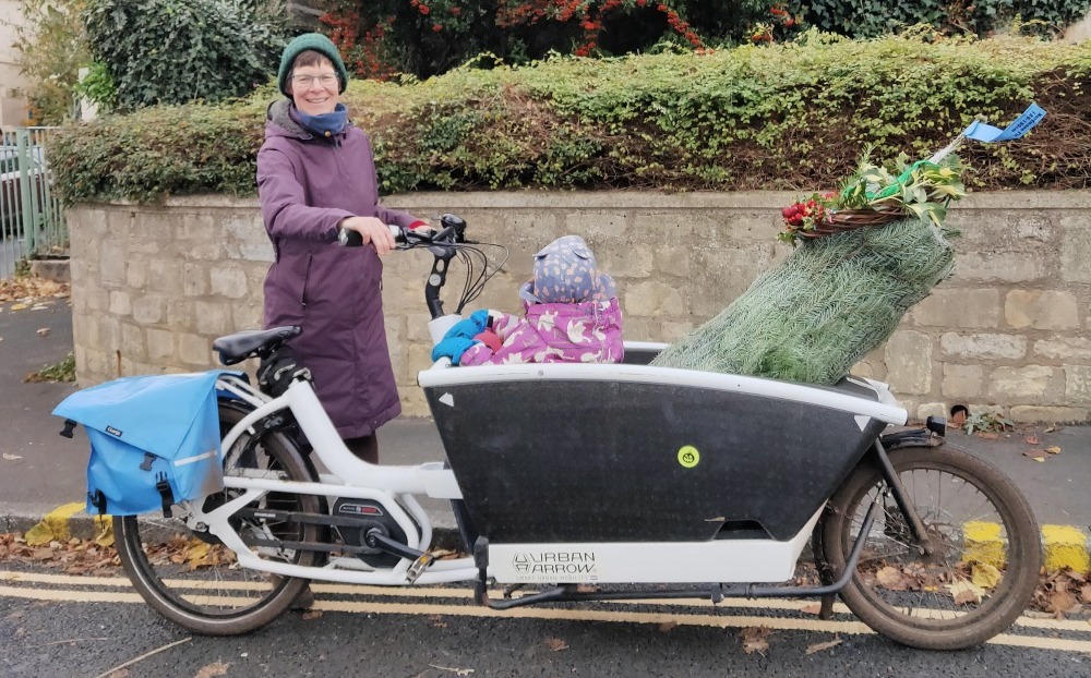 Cargo box bike with Christmas tree and child in it Mycle cargo bike christmas tree and toddler