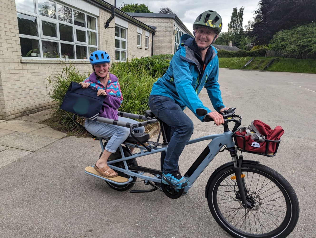 cycling to school- a mum and dad on cargo bike after school drop off