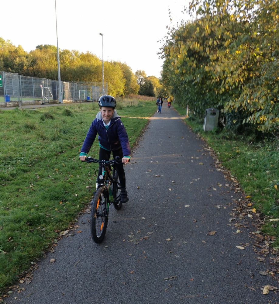 Girl cycling to school wearing school uniform