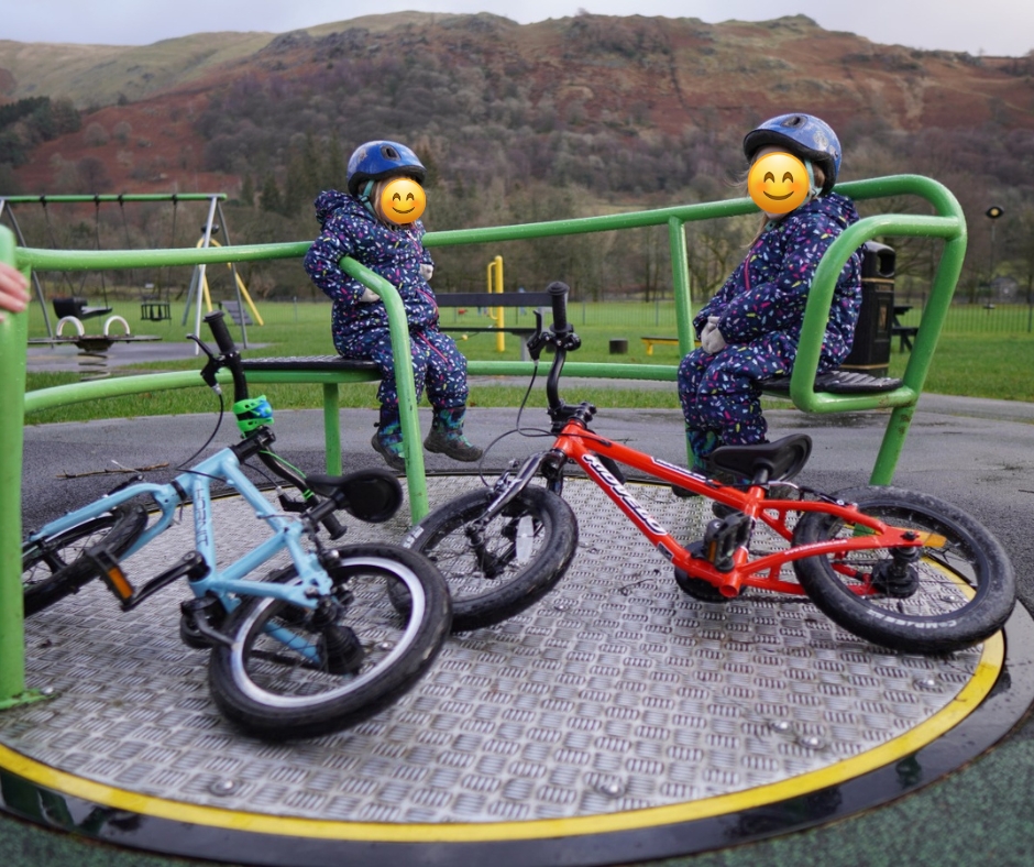 twin sisters on a roundabout with their bikes