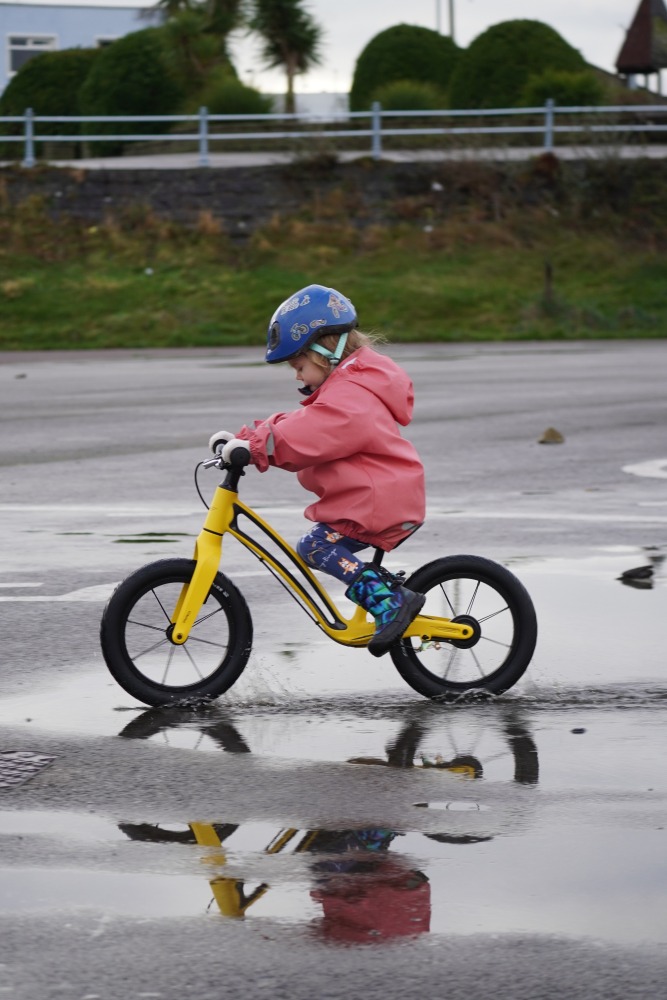 girl riding on yellow balance bike