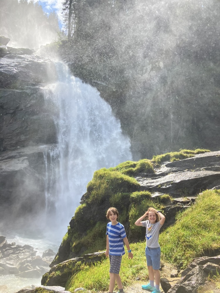 family cycling routes in Austria & italy: Bea Searle's two children standing in front of a waterfall