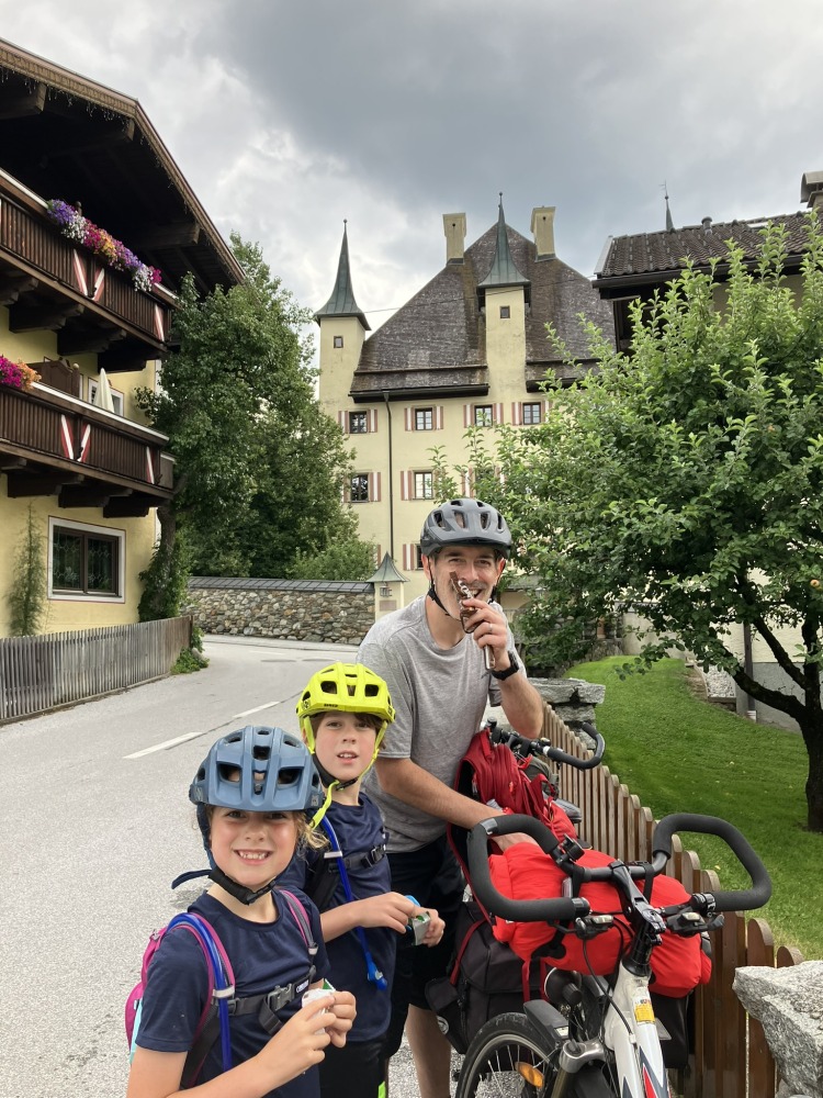 family cycling routes in Austria & italy: Bea's partner and children stopped for snacks, still wearing their helmets