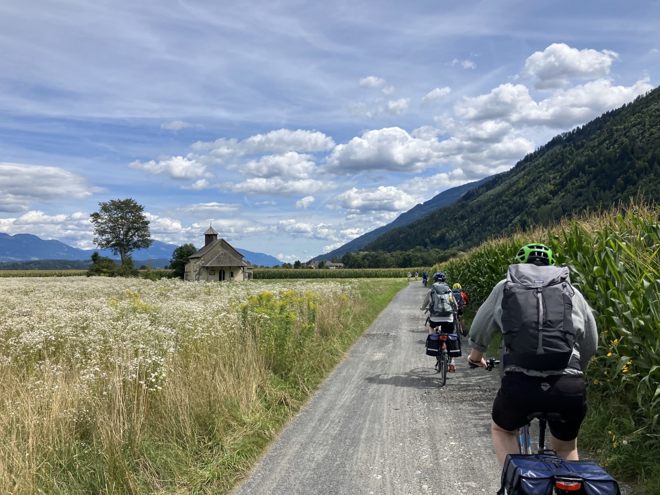 family cycling routes in Austria & italy: Bea's partner and child cycling long a smooth gravel path, seen from behind
