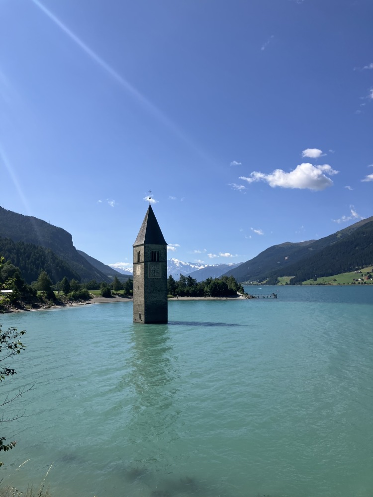 family cycling routes in Austria & italy: The sunken bell tower rising from the middle of Lake Reschen on the Adige cycle path
