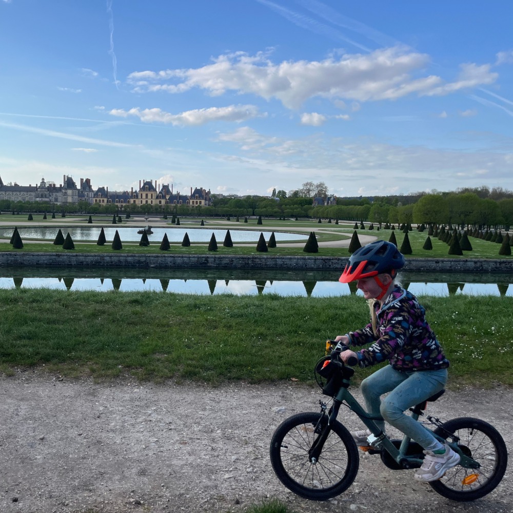 BTWIN 16 Discover 900 review- a girl in a flowery top riding her blue bike