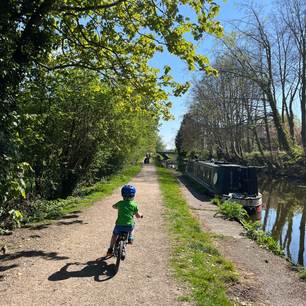 BTWIN 16 Discover 900 review- a smiling 3 year old riding along a canal