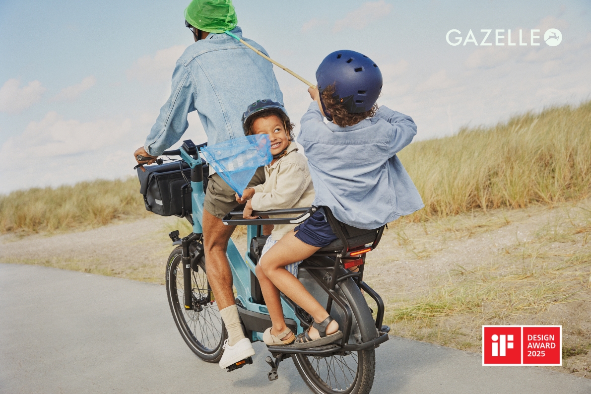 Gazelles images of the cabby longtail cargo bike in use- a family of three riding the blue bike to the seaside