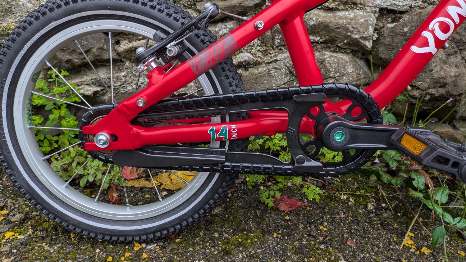 YOMO 14 review: the red bike leant against a wall- close up of the chain guard