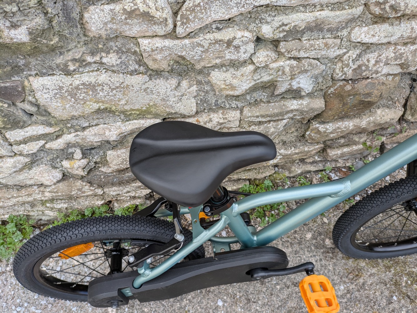 A photo of the BTWIN 16” Discover 900 leant against a wall for its review- close up of the saddle