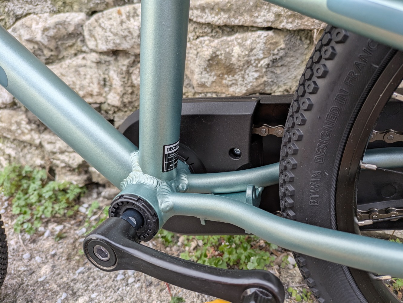 A photo of the BTWIN 16” Discover 900 leant against a wall for its review- close up of the crank