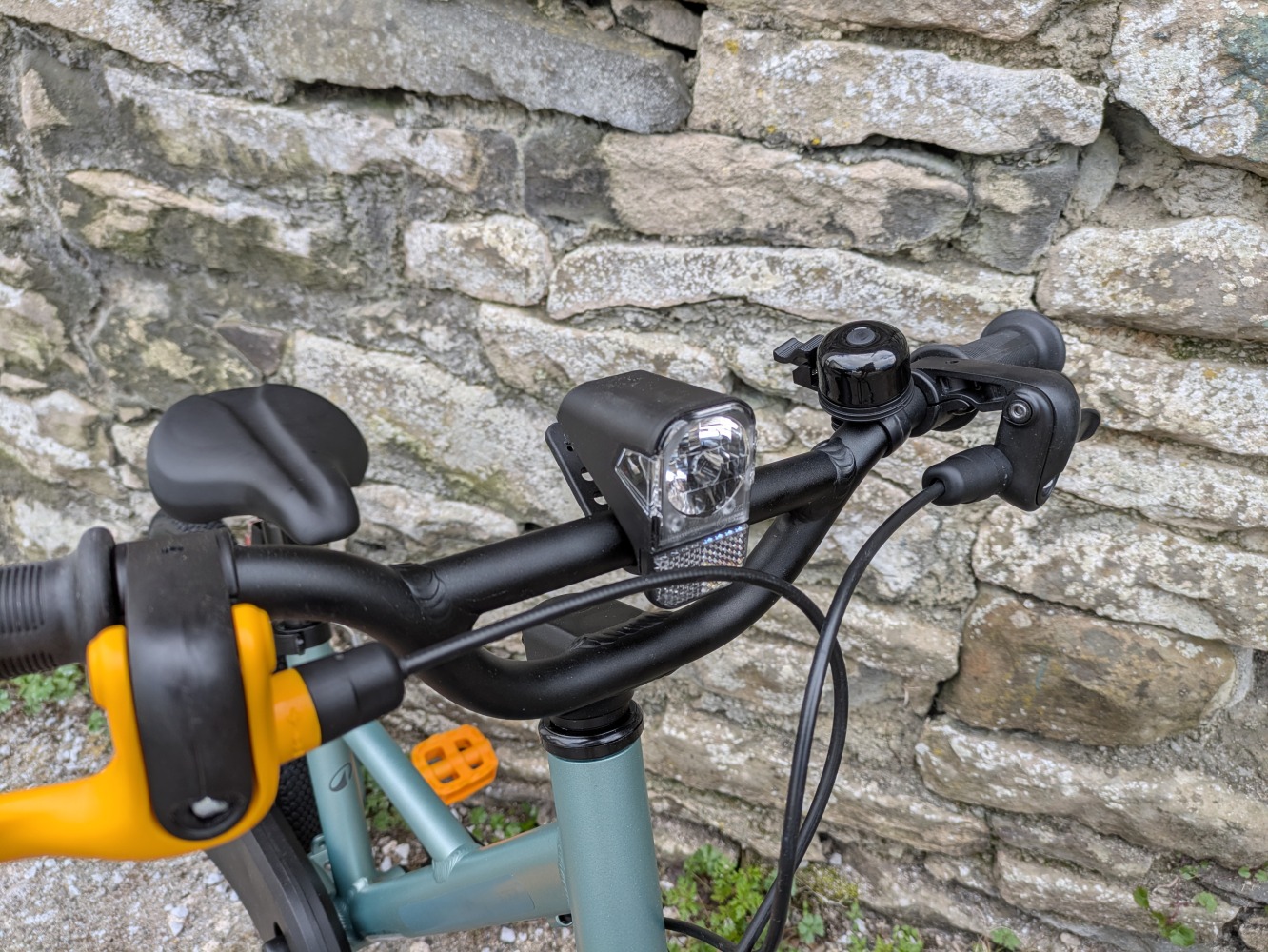 A photo of the BTWIN 16” Discover 900 leant against a wall for its review- close up of the handlebars