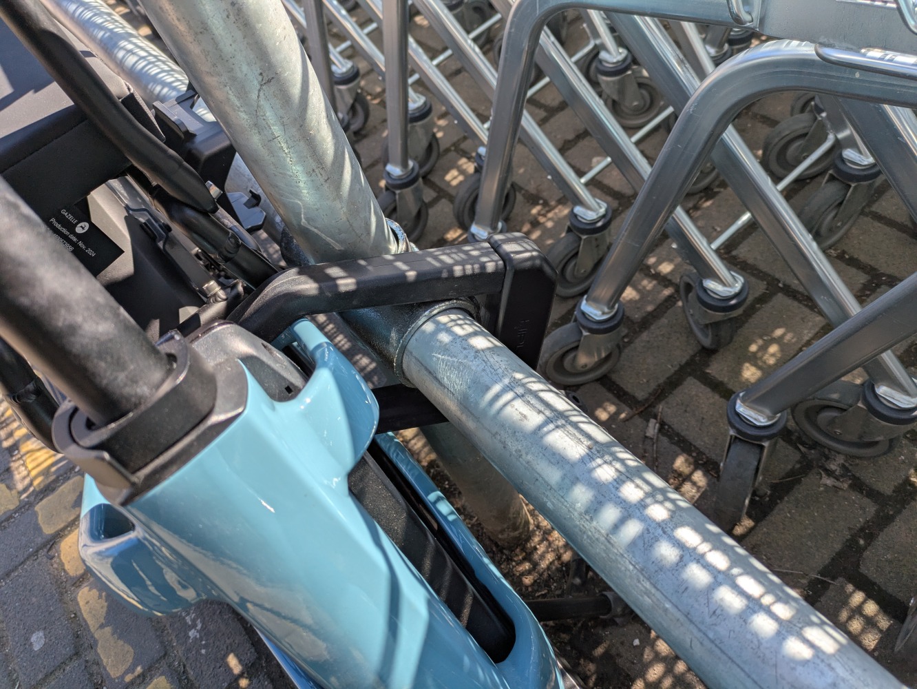 A black hiplok D1000 locking a blue, Gazelle Cabby longtail cargo bike