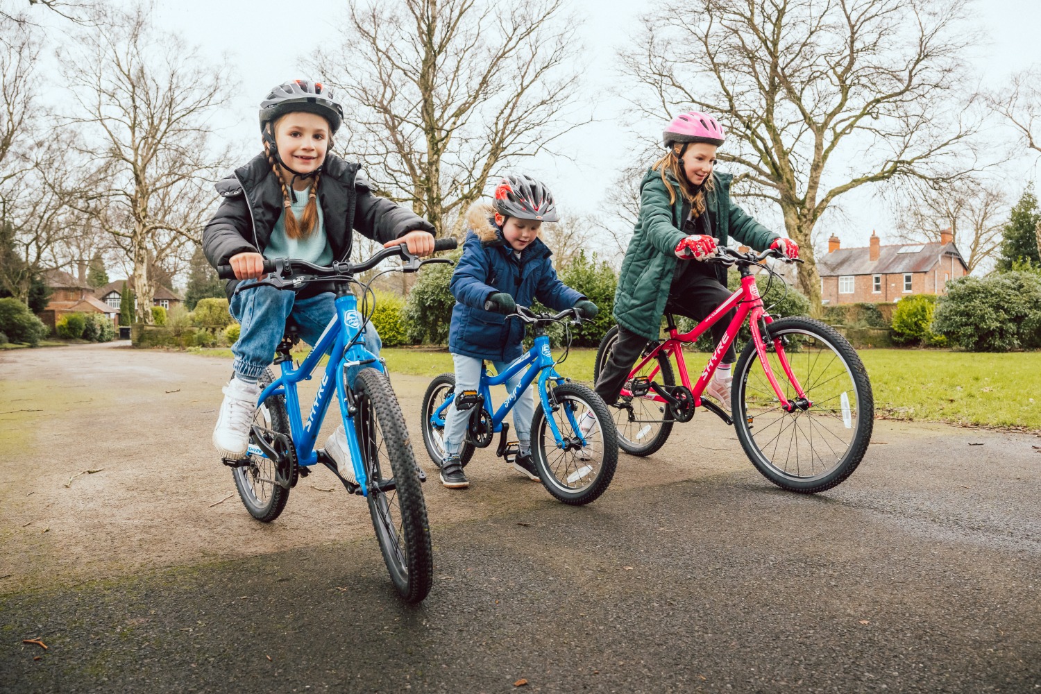 three kids riding shyre bikes side by side
