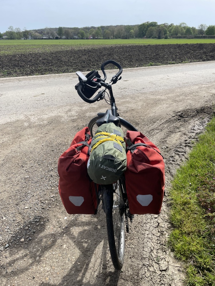 A view of Sahir's cycle touring bike with butterfly handlebars, big panniers and a tent strapped to the rear rack