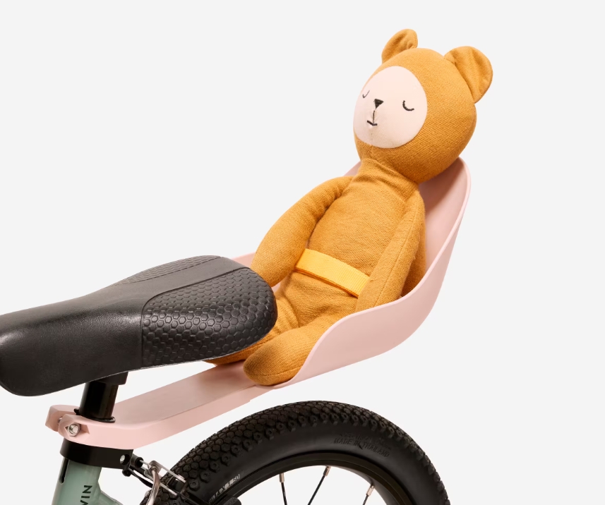 Best bike accessories for kids: A toy baby seat attached to the back of a kids bike with a teddy bear in it