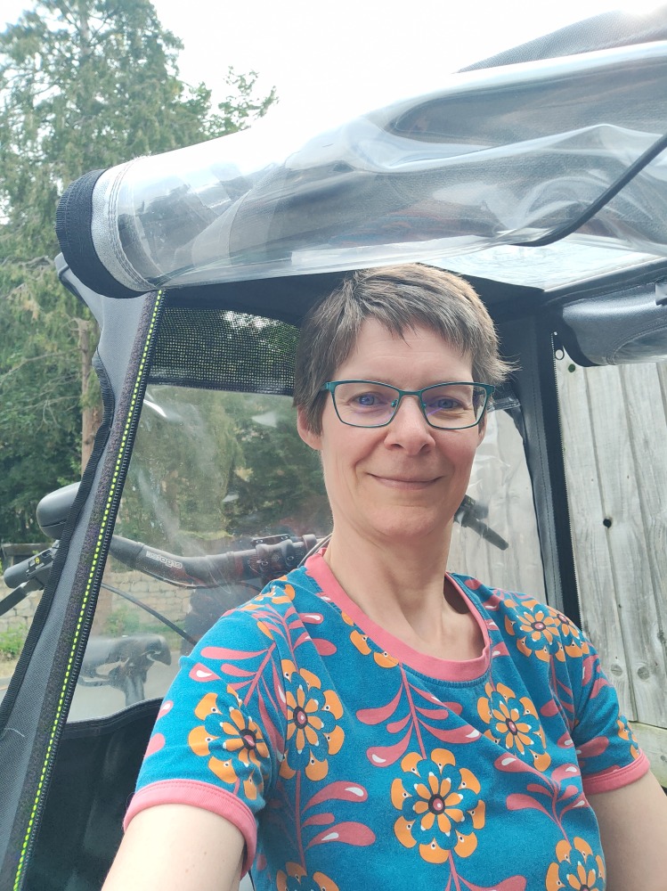 Adult sitting in Urban Arrow Family rain canopy
