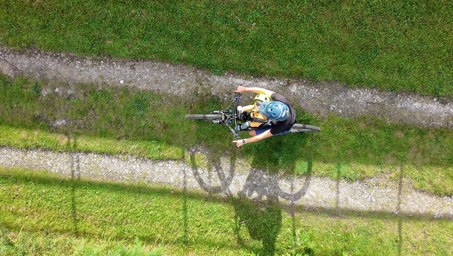 kids ride shotgun pro evo baby seat review- a photos of a little boy in a yellow helmet smiling on a bike ride with his mum