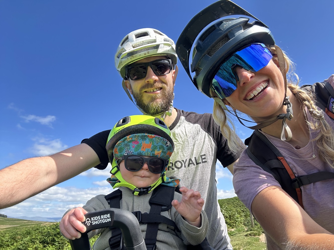 a selfie of a family with their son in the kids ride shotgun pro evo seat