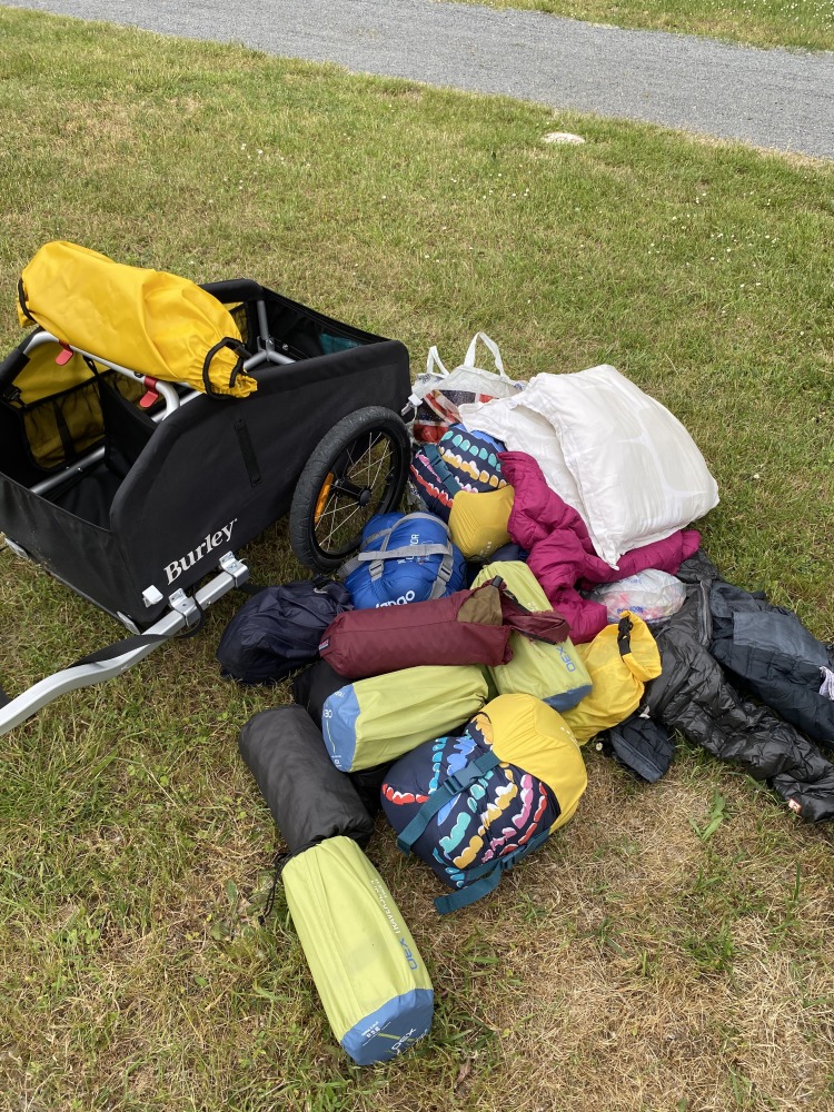 A massive pile of camping eqiopment about to go into the yellow and black burley nomad cargo trailer