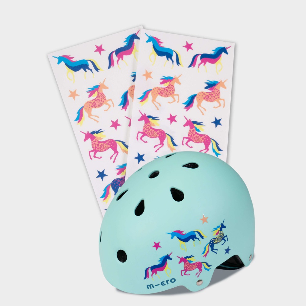 Best bike accessories for kids: Unicorn stickers on sheets next to a helmet with stickers on it