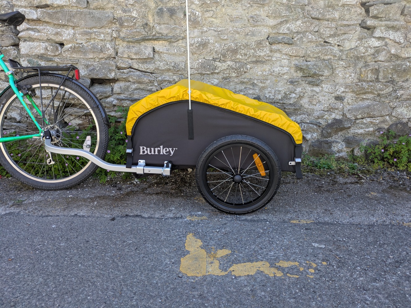 the yellow and black Burley Nomad cargo trailer against a wall