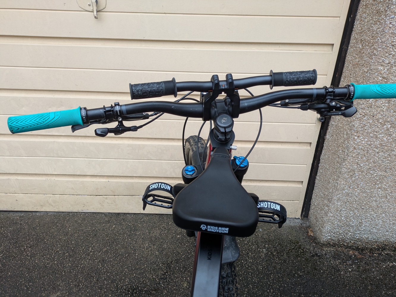 A Kids Ride Shotgun Pro Evo seat, in toddler mode mounted to a red trek MTB with pro handlebars