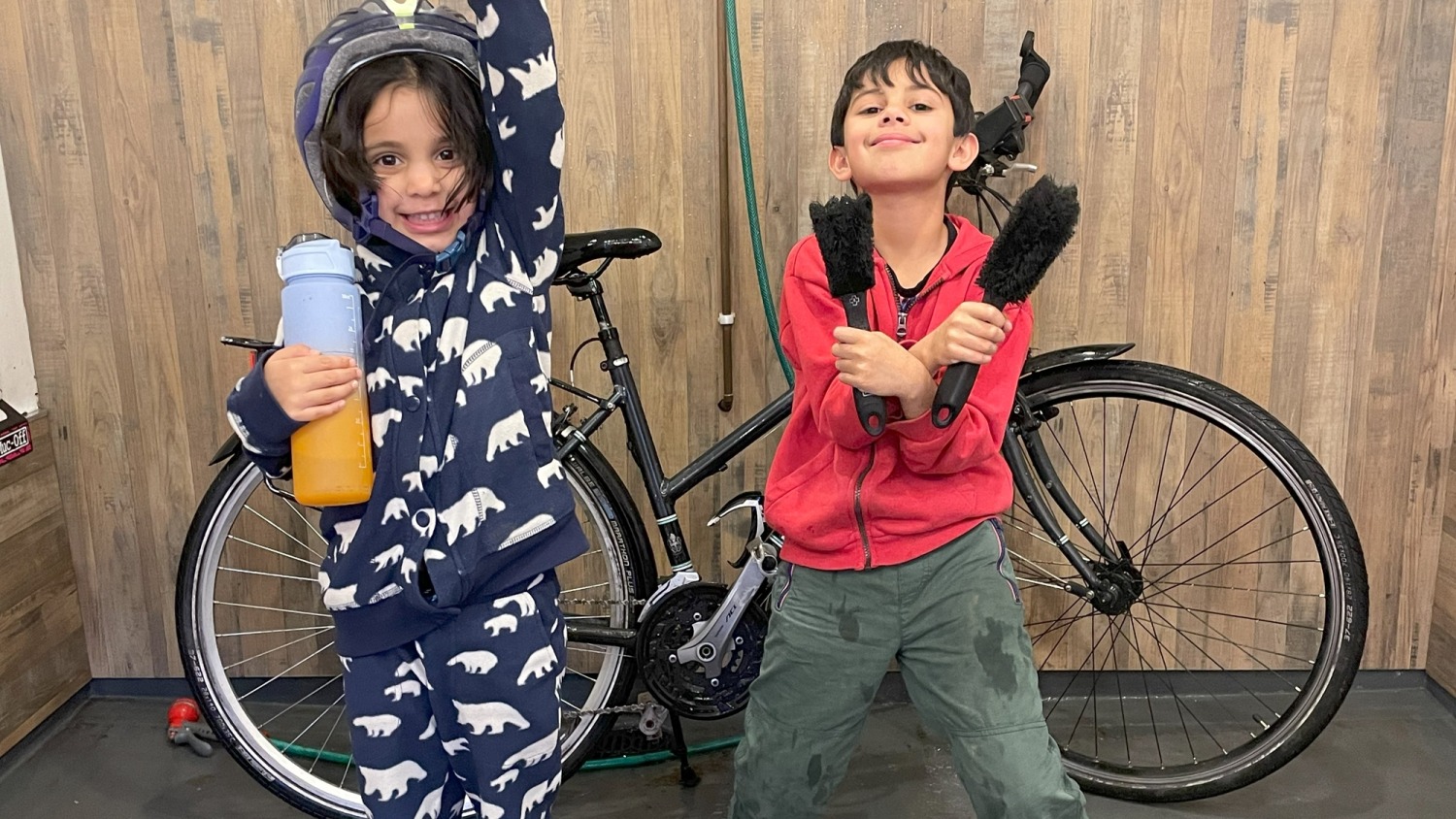 Sahir's children helping to wash her cycle touring bike 