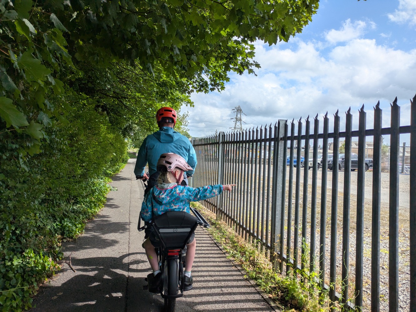 Gazelle Cabby review- a dad in a blue coat and orange with his daughter in a blue jacket and pink helmet and school dress riding the gazelle cabby