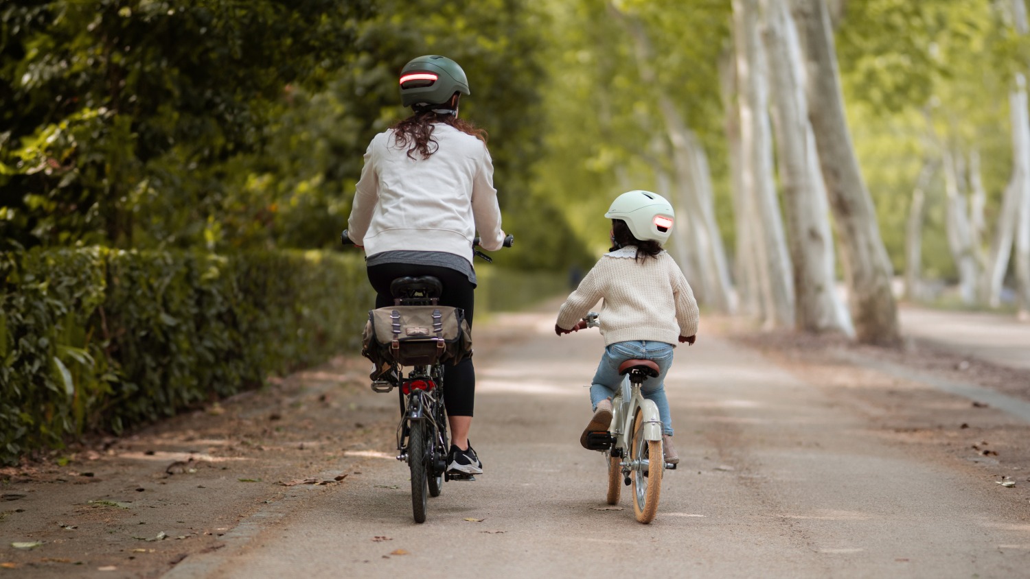 Mum and child riding their bikes, both wearing helmets from UNIT 1