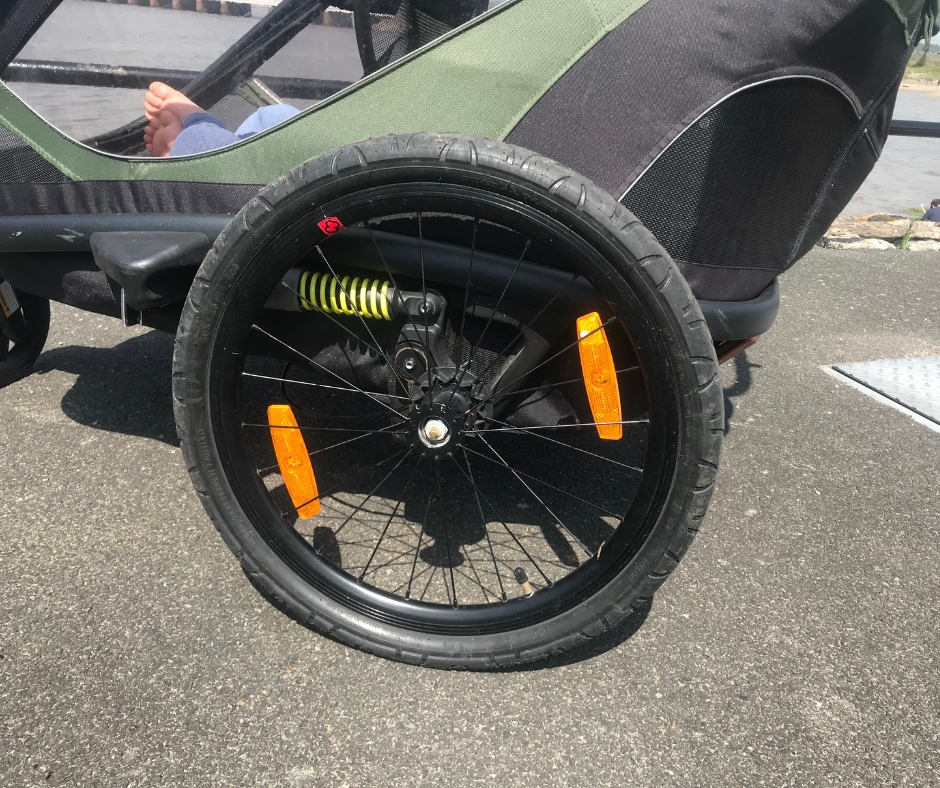 A green Hamax Outback double trailer- a close up of the wheel