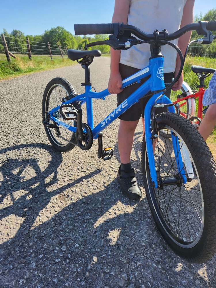 Shyre Hopton 20 review: A close up of the Shyre Bike, seen from the front, being held by the top tube, by a boy