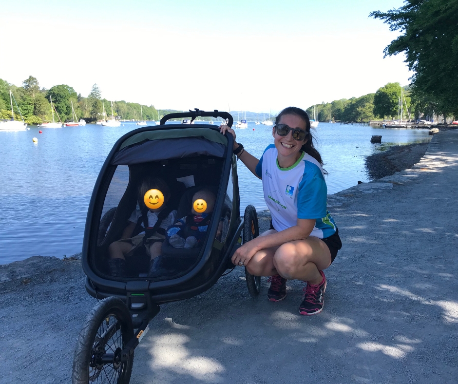 a mum smiling after finishing park run with her two children in the Hamax Outback trailer