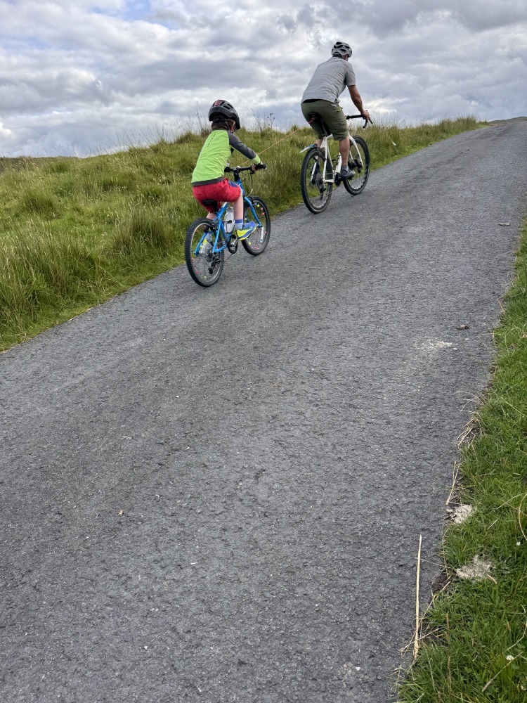 dad and son riding uphill with the Zefal Bike Taxi tow rope review