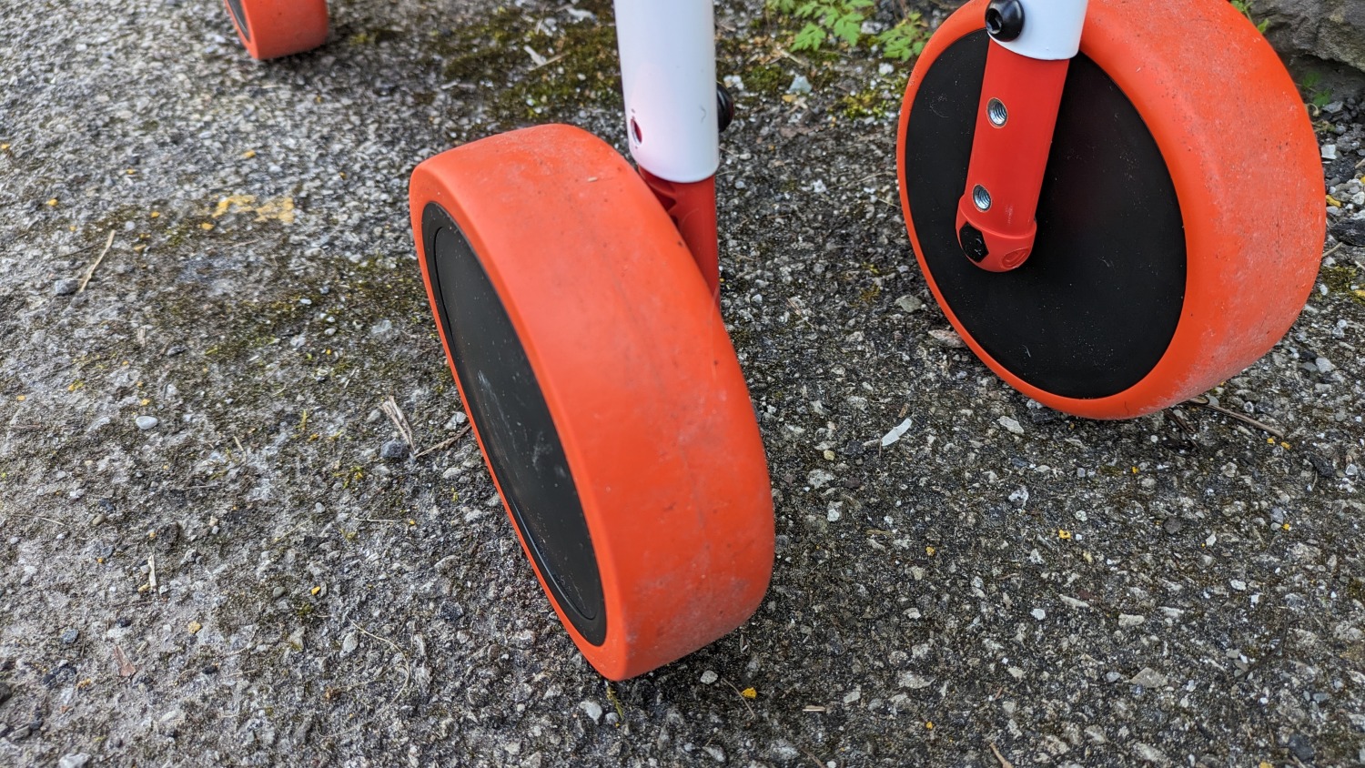 Btwin Convertible 2-in-1 Ride-On to Balance Bike, a white, orange and blue bike- close up of the wheel