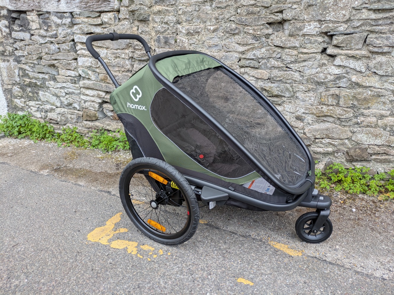 A green Hamax Outback double trailer- a close up of the