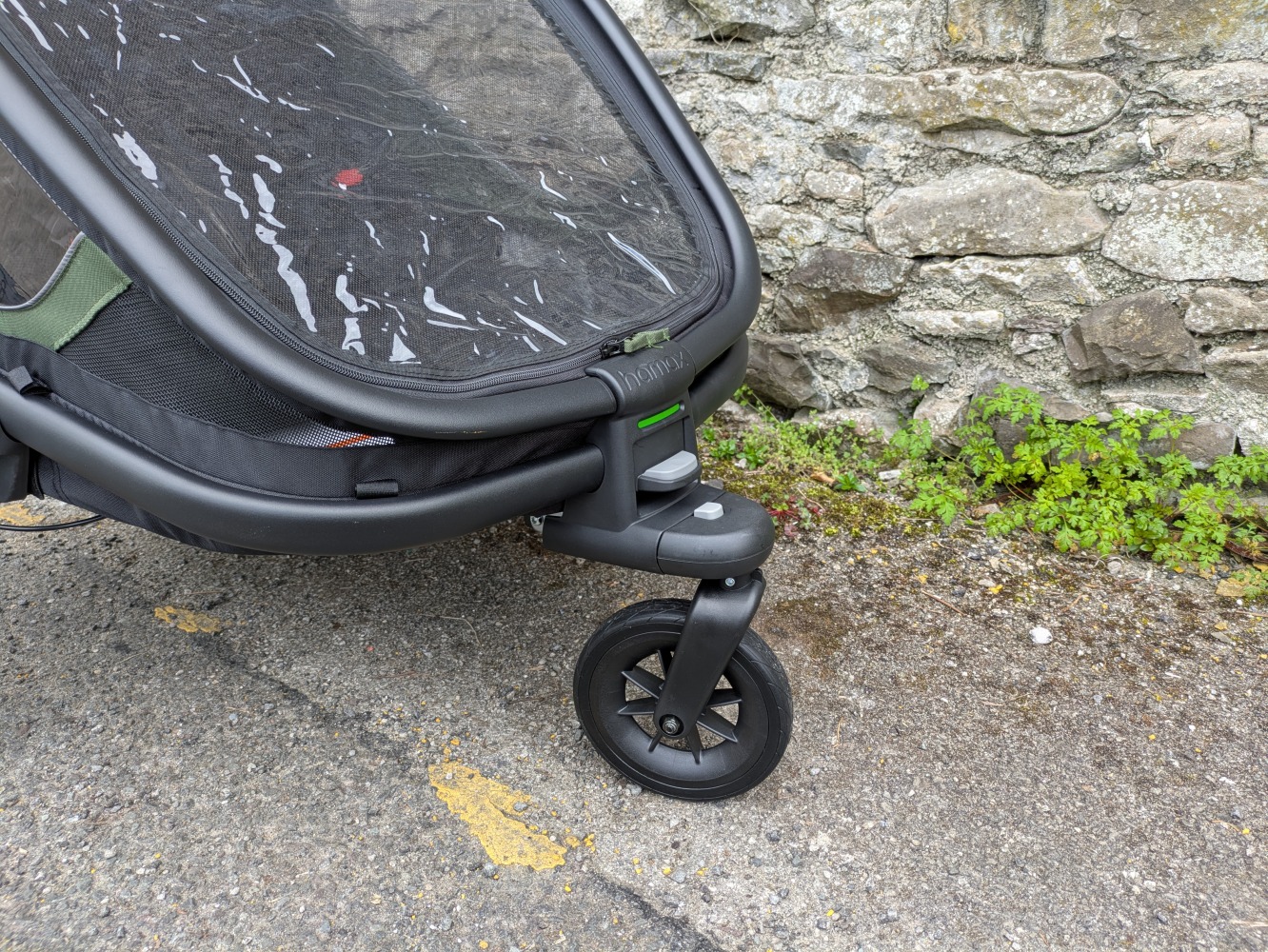 A green Hamax Outback double trailer- a close up of the strolling wheel