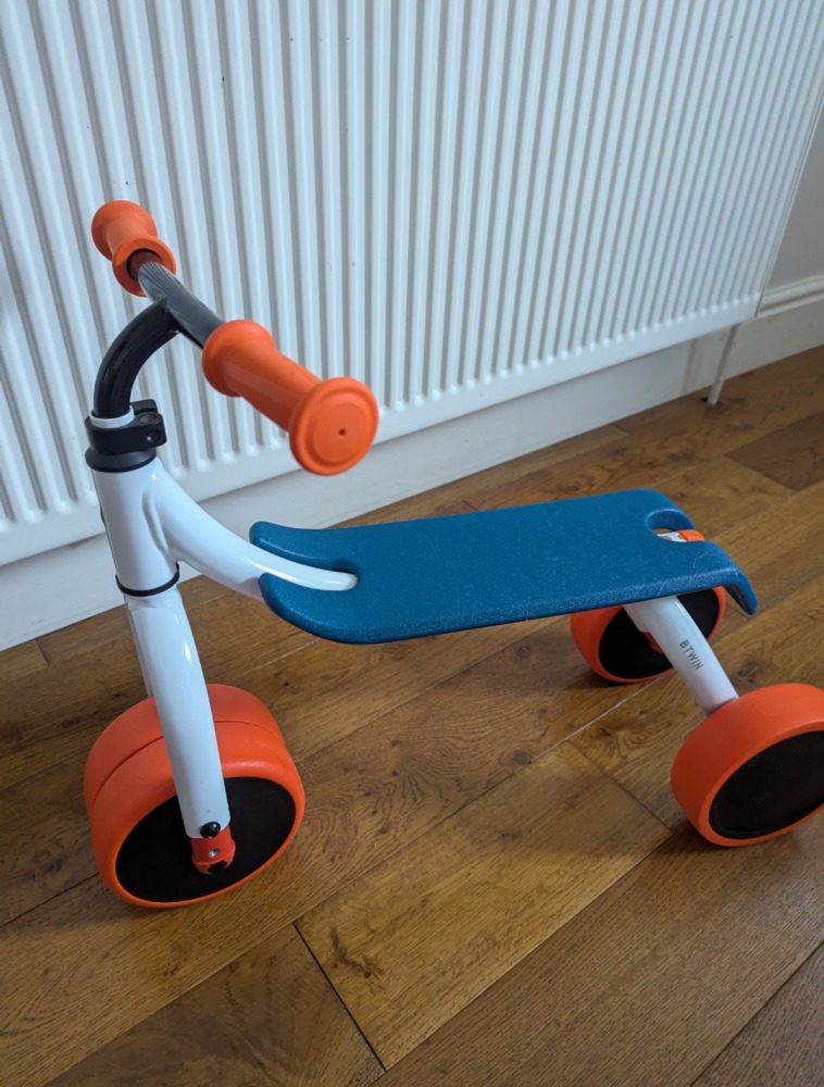 Btwin Convertible 2-in-1 Ride-On to Balance Bike, a white, orange and blue bike