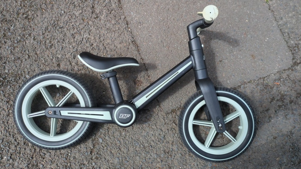 A blue and black Be Fun wheels folding balance bike laying on the floor
