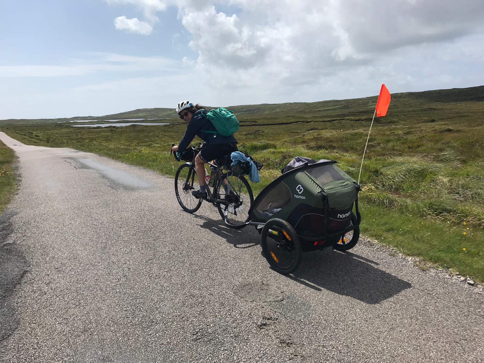 Hamax Outback trailer riding up a lane on a sunny day