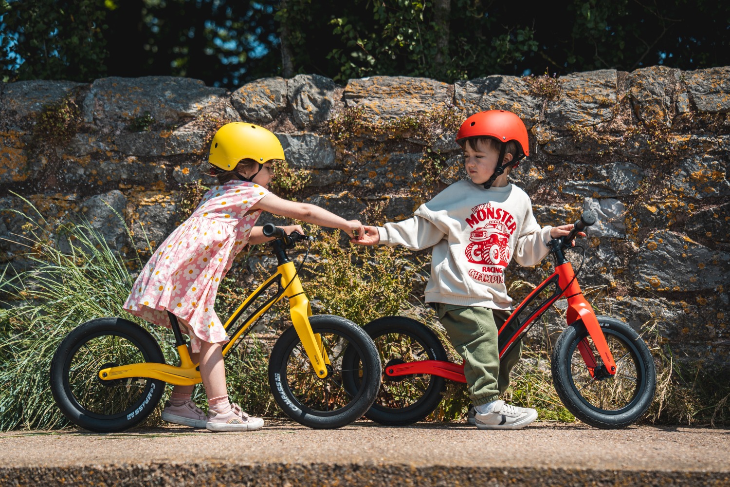 Two toddlers on Hornit AIRO 14s, reaching towards each other