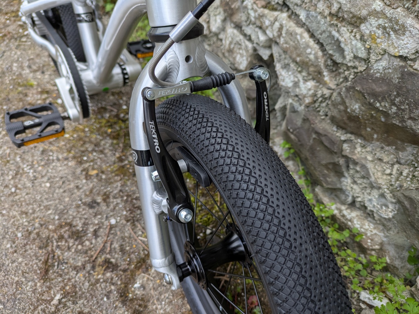 A close up of the front brake and ture on the silver, early rider belter 14 inch- cycle sprog rider review