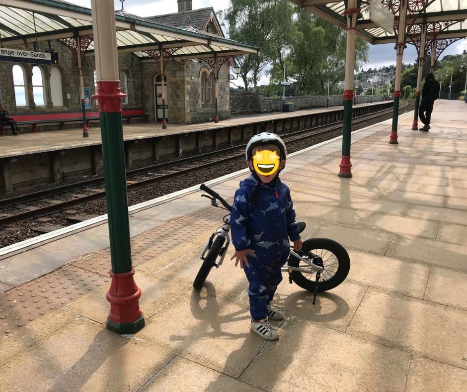 A little boy with his Early Rider Belter 14 on a train platform