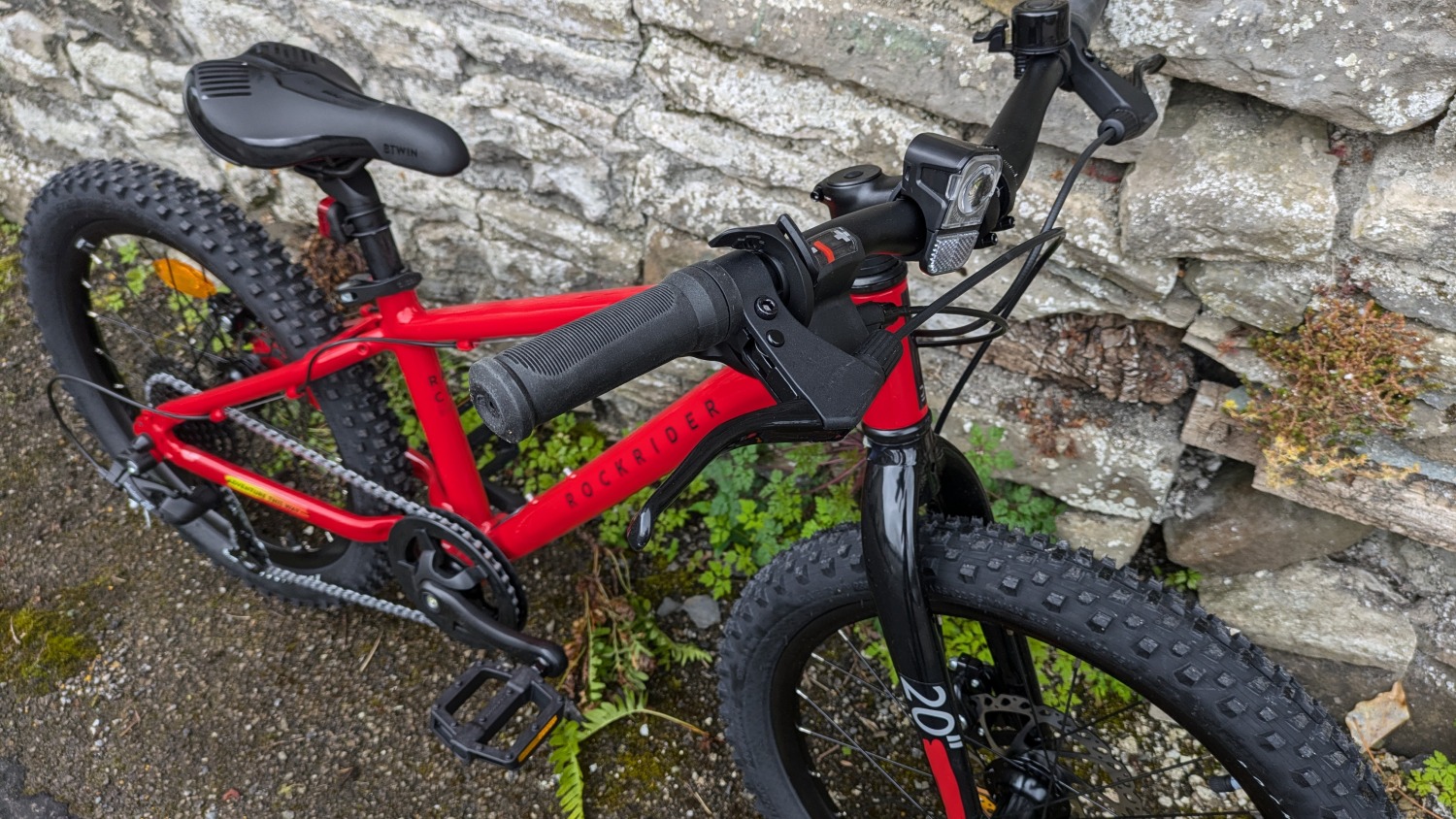 20 inch BTWIN EXPL 900r kids mountain bike leant against a wall- close up of the brake lever 
